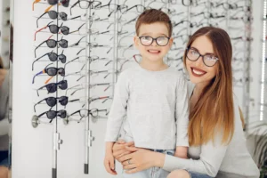 mãe e filho após escolherem uma armação de óculos infantil